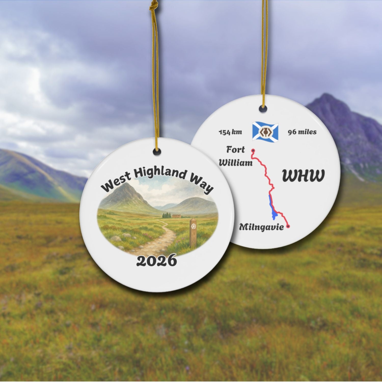 West Highland Way ceramic ornament with watercolor landscape shown front and back in front of trail landscape.