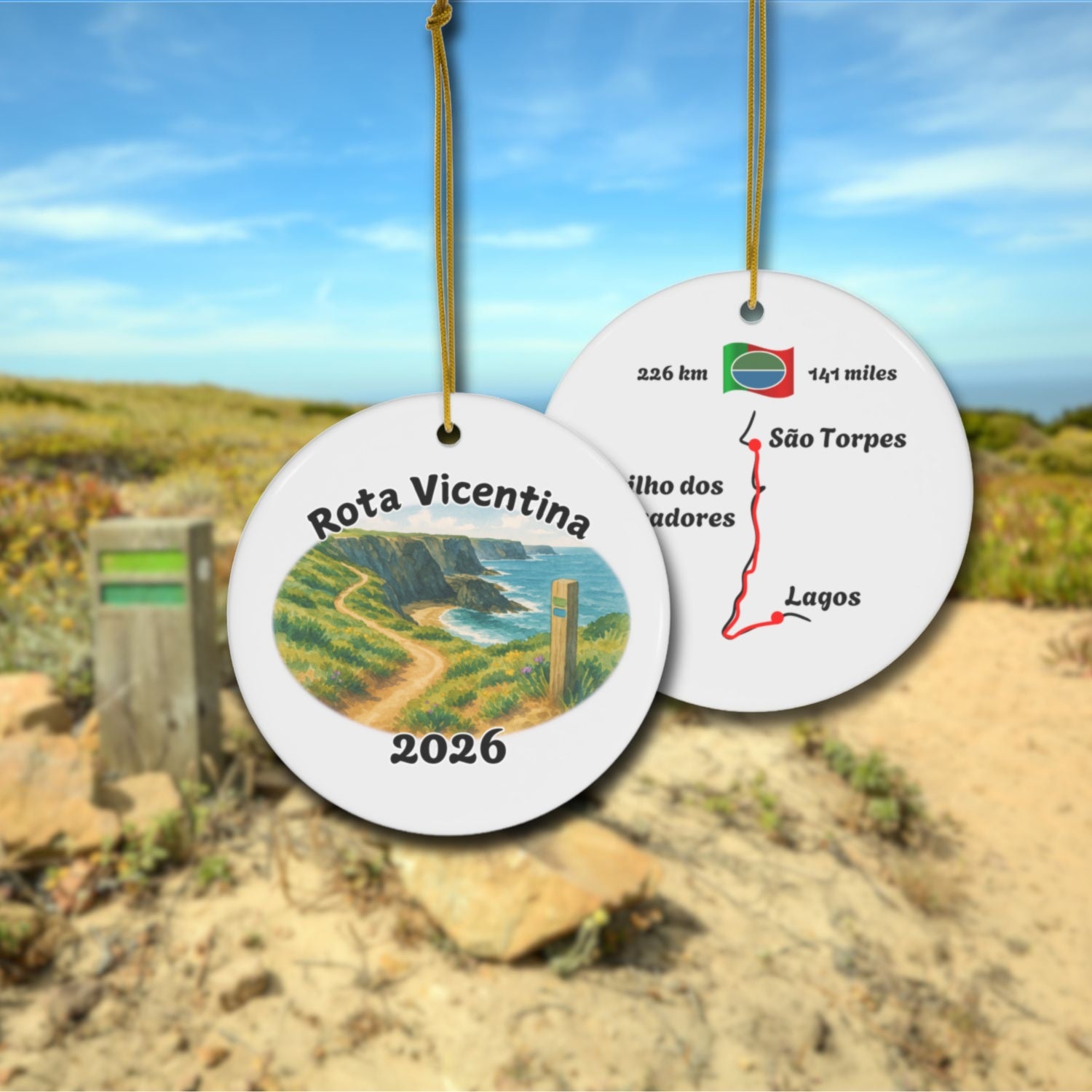 Rota Vicentina ceramic ornament with watercolor landscape shown front and back in front of trail landscape.
