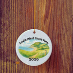 Basic version of South West Coast Path ornament in front of wooden door.