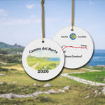 Camino del Norte ceramic ornament with watercolor landscape shown front and back in front of trail landscape.