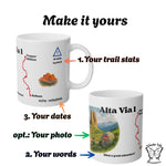 Mockup of the customizable Alta Via 1 mug with labels showing where you can add your distance, your travel dates, and your own words below the watercolor scene.