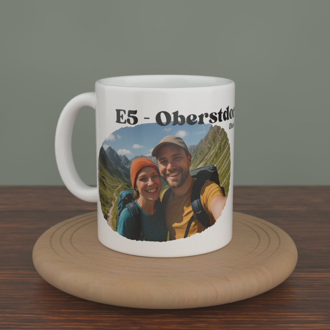 Video of a white E5 Oberstdorf - Meran mug turning slowly, showing the photo edition with your own picture and the route map.